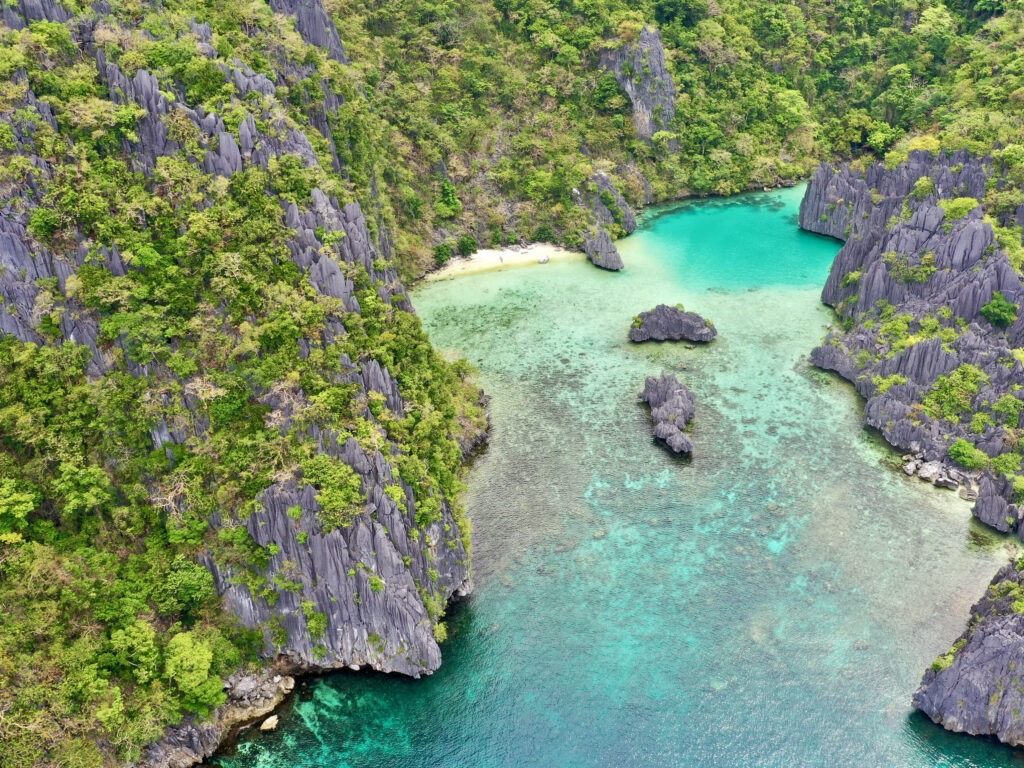 "Crystal-clear water at Cadlao Lagoon framed by limestone cliffs, El Nido
