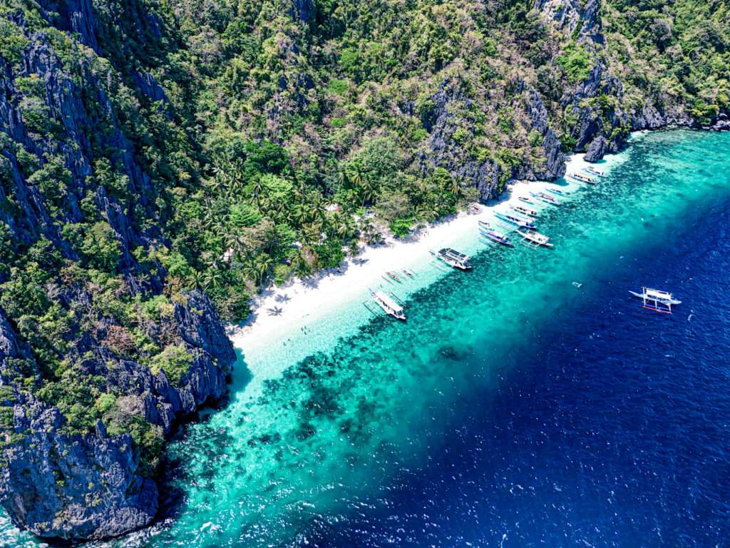 Boats anchored off Entalula Island's beach with a lunch spread set up