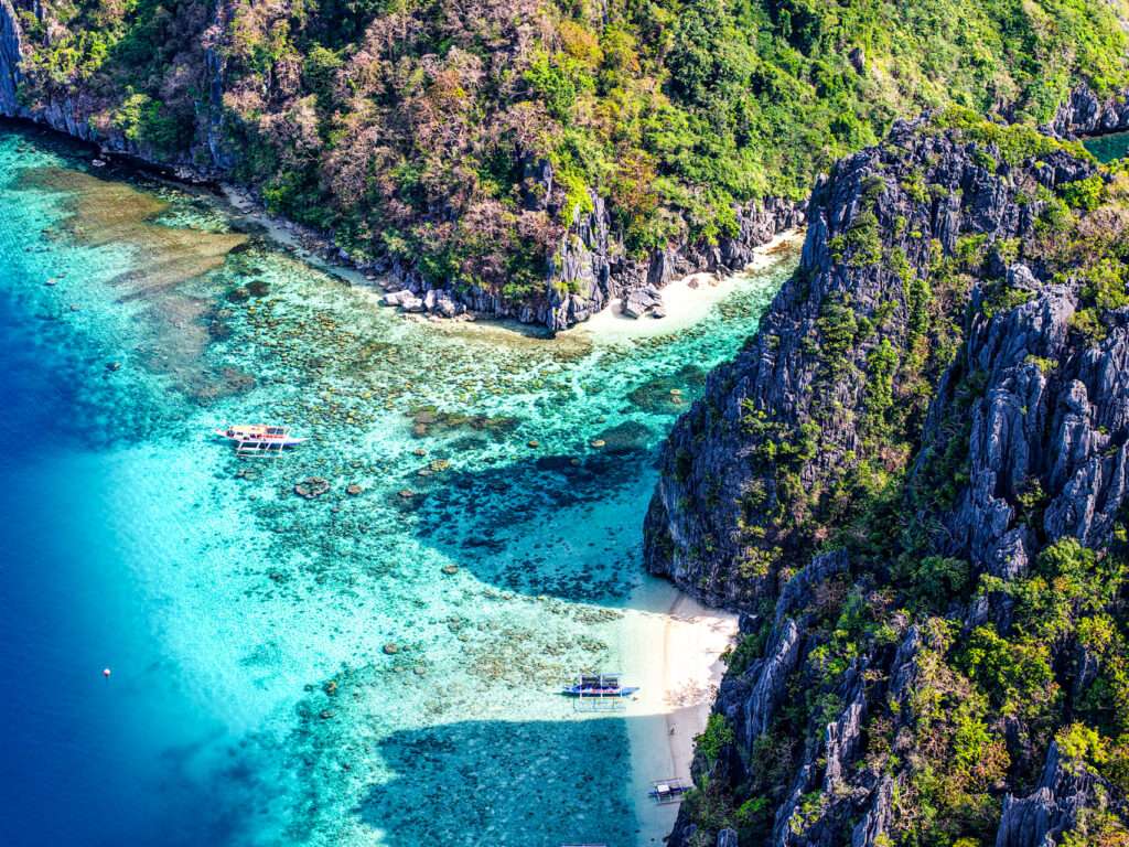 Snorkeler swimming over coral near Shimizu Island, El Nido