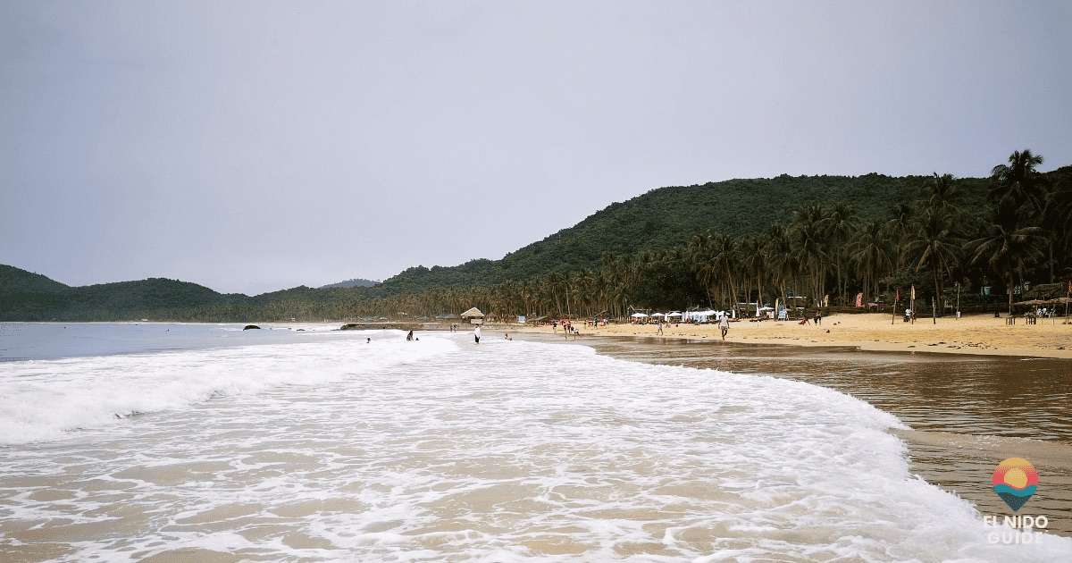 Dramatic green-season sky over a wide empty beach in El Nido on a rough-sea day