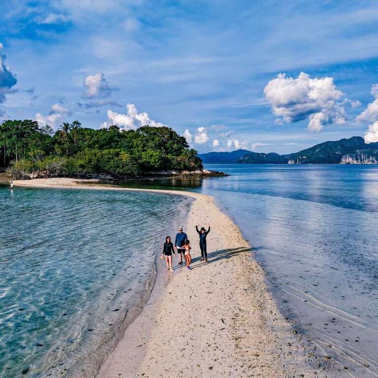 Visitors walking along the narrow Snake Island sandbar at low tide, El Nido