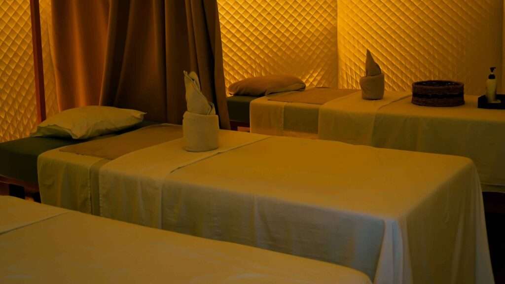 Spa treatment room with twin massage beds in warm light at Nacpan Beach Resort, El Nido
